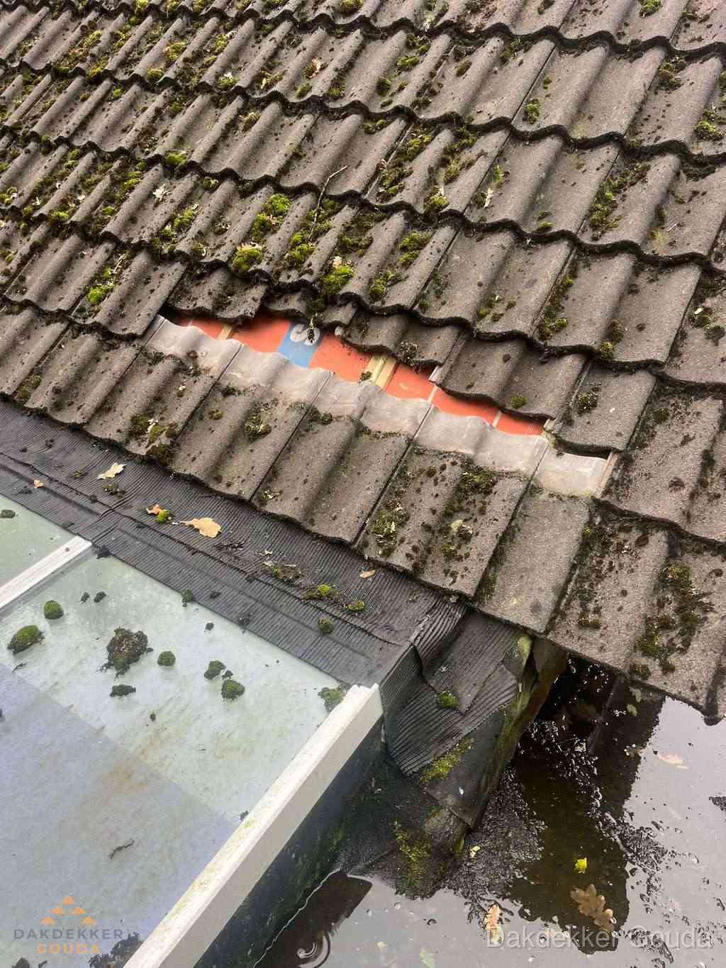 Beschadigd pannendak met ontbrekende dakpannen voor reparatie in Gouda