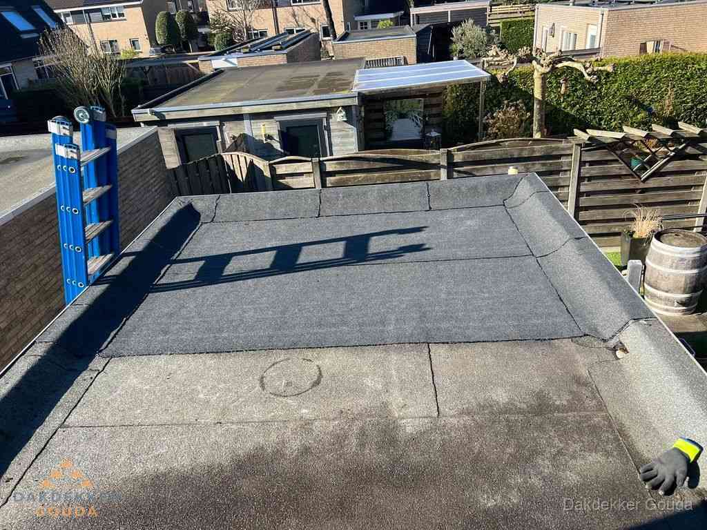 Dakdekker legt onderlaag op plat dak met houten constructie in Gouda
