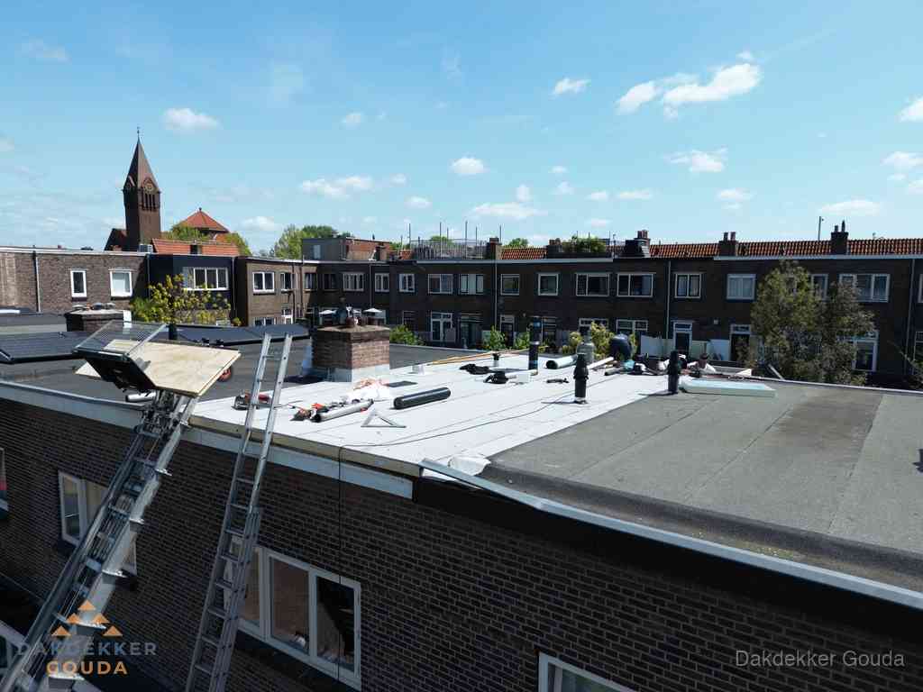 Dakdekkers aan het werk op plat dak in Gouda