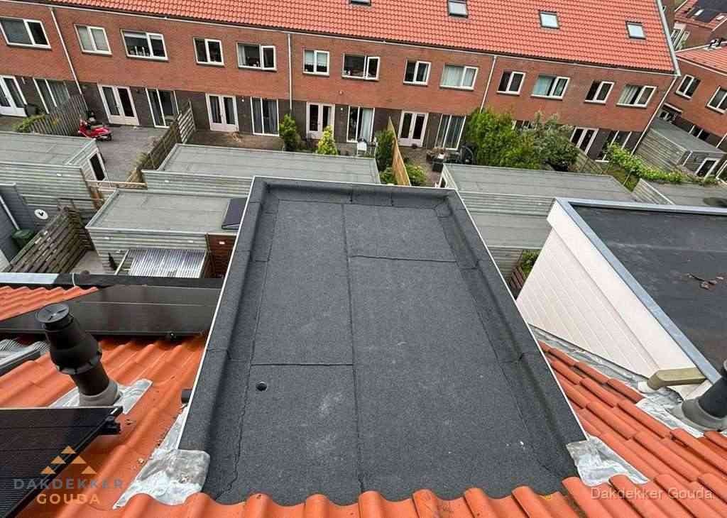 Plat dak met bitumen bedekking naast dakkapel in Gouda