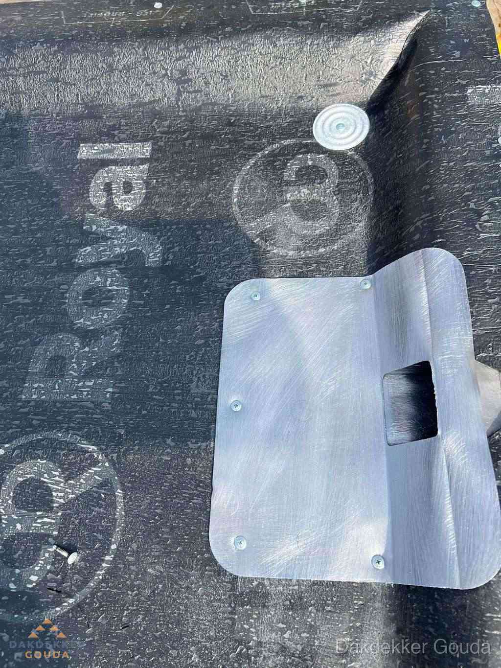 Dakdoorvoer met metalen afvoerplaat op bitumen dak in Gouda