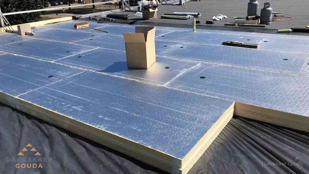 PIR isolatieplaten worden gelegd op plat dak voor dakisolatie in Gouda