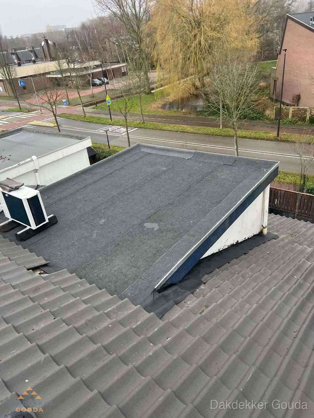 Plat dak met bitumen dakbedekking naast schuin pannendak in Gouda