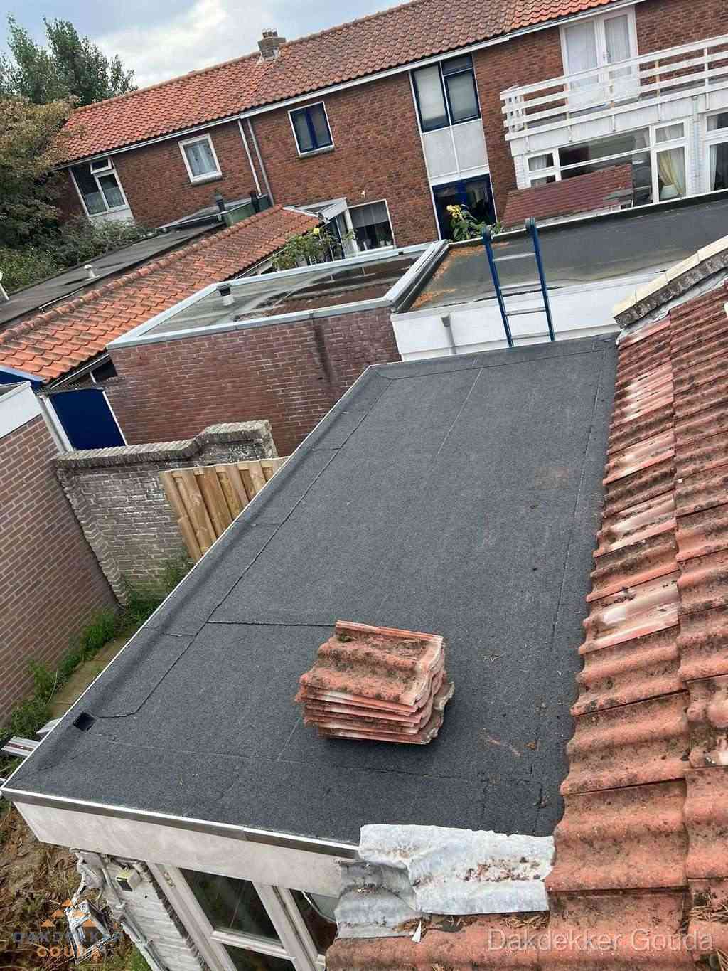 Aanbouw plat dak met reservepannen voor dakpannen vervangen in Gouda
