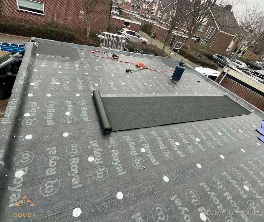 Dakdekker aan het werk met gasbrander op plat bitumen dak in Gouda