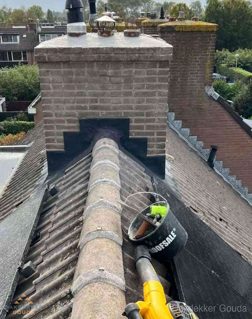 Dakdekker repareert bitumen dakleer bij dakdoorvoer in Gouda
